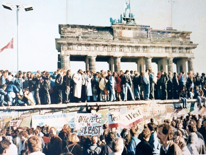 5b80190591132-west-and-east-germans-at-the-brandenburg-gate-in-1989.jpg
