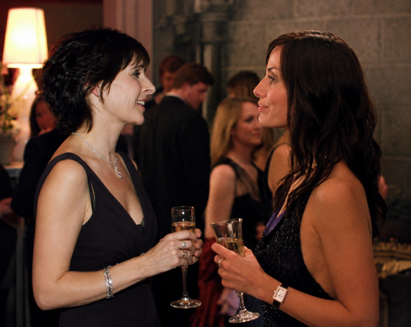 Enya and Natalie Imbruglia at a fancy party holding champagne flutes