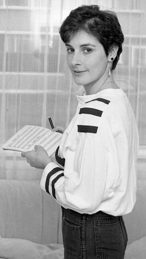 Enya, 1985 standing holding music.png