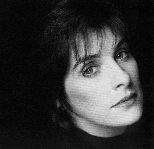 ♡ (Enya, early 90s photo) This may contain: a black and white photo of a woman with short hair looking off to the side