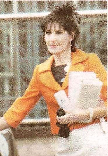 ♡ (haha the visual thing) This may contain: a woman in an orange jacket holding a tennis racquet and wearing white pants