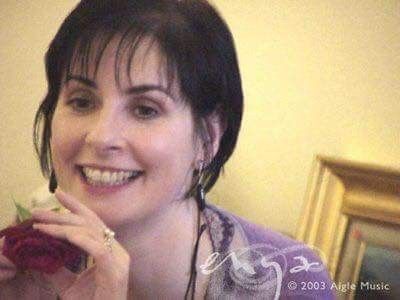 This may contain: a woman is smiling while holding a flower